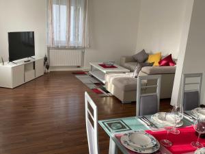 uma sala de estar com um sofá, uma televisão e uma mesa em Black Forest Apartment em Baden-Baden