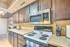 a kitchen with a stove and a microwave at Peoria Oasis with Resort Amenities, 2 Mi to Downtown in Peoria