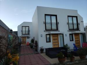 ein weißes Haus mit Türen und einer Terrasse in der Unterkunft Loft Terrazas de Cachagua in Zapallar