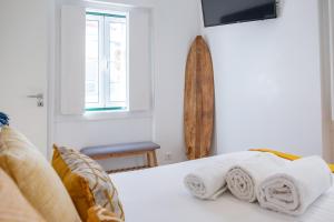 um quarto com uma cama com toalhas em Feel Nazaré - Abegoarias 62 na Nazaré