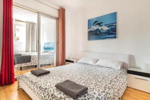 a bedroom with a bed and a large window at Dream House in Badalona