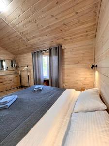 un grande letto in una camera con pareti in legno di Treeskit House a Horenka