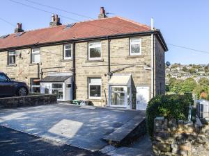 a brick house with a car parked in front of it at Holme Valley Cottage in Holmfirth