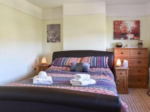 a bedroom with a bed with towels on it at Holme Valley Cottage in Holmfirth