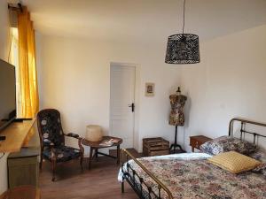 a bedroom with a bed and a table and a chair at Pavillon d'Aÿ cottage Champagne - Label Green Key - Epernay, Aÿ in Ay
