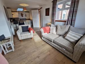 a living room with a couch and two chairs at Little Red Kirriemuir in Kirriemuir