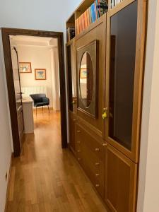 um corredor com um grande armário de madeira com um espelho em La casa di Panfilo em Sulmona
