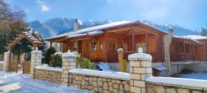 a wooden house with a fence in the snow at Xylino Chalet in Kalavrita