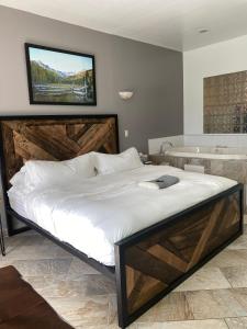 a bedroom with a large bed and a bath tub at Pikes Peak Paradise Bed and Breakfast in Woodland Park