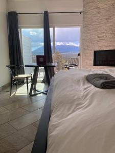 a bedroom with a bed and a table with a laptop at Pikes Peak Paradise Bed and Breakfast in Woodland Park