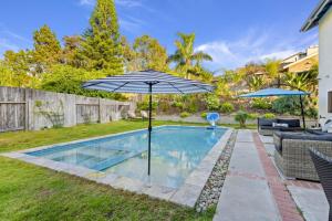 a swimming pool with an umbrella in a yard at Mira Costa Majesty in Oceanside