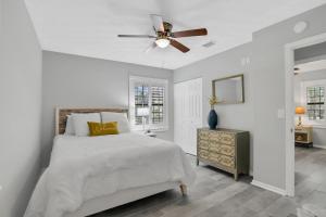 een witte slaapkamer met een bed en een plafondventilator bij 4636 Whimbrel Lane in Fernandina Beach