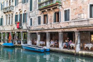 a couple of boats in the water in front of buildings at Hotel al Sotoportego in Venice
