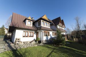 a white house with a brown roof at Domek Pod Reglami in Zakopane