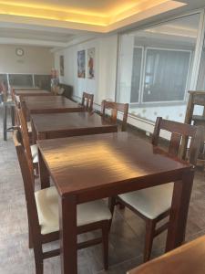 a row of wooden tables and chairs in a room at Lujan Homes in Luján
