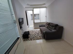 ein Wohnzimmer mit Sofa und Fernseher in der Unterkunft Residencia Cidade Verde 14 in Maringá