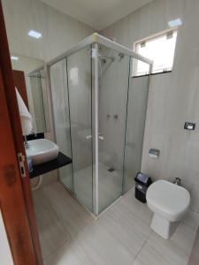 uma casa de banho com um chuveiro, um WC e um lavatório. em Residencia Cidade Verde 14 em Maringá