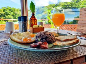 - une assiette de petit-déjeuner et un verre de jus d'orange dans l'établissement Hotel Ficus - Monteverde, à Monteverde Costa Rica