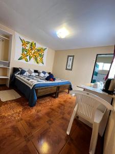 1 dormitorio con 1 cama y 1 silla en Camping Hostal Tipanie Moana Aeropuerto Centro, en Hanga Roa
