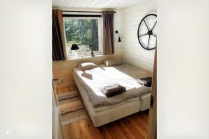 uma cama num quarto com uma janela em Sjöstugan, Solviken em Rockneby