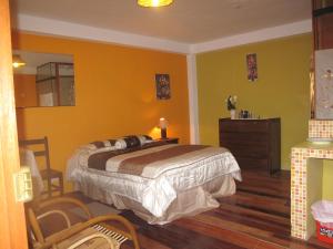 1 dormitorio con 1 cama y paredes amarillas en Casa de Mama Cusco 2-The Ecohouse, en Cusco