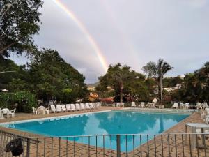 einen Regenbogen über einem Pool mit Regenbogen in der Unterkunft Hotel Miguel Pereira in Miguel Pereira
