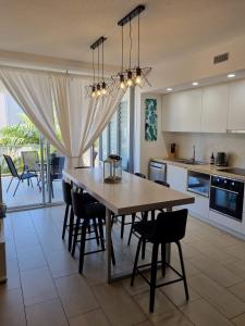 a kitchen and dining room with a table and chairs at 1213/146 Sooning street, Nelly Bay, Magnetic Island. Qld 4819. One Bright Point. in Nelly Bay