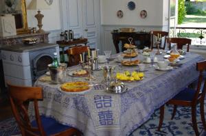 una mesa con comida en la cocina en Château de Pommeuse, en Pommeuse