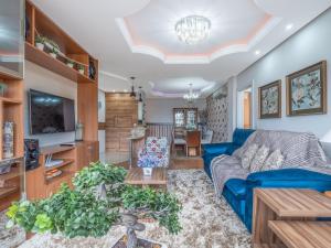 uma sala de estar com um sofá azul e uma mesa em Fascino 302 - Apartamento 600 metros Rua Coberta de Gramado em Gramado