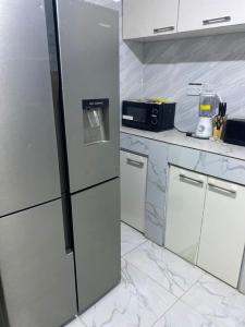 uma cozinha com electrodomésticos em aço inoxidável e balcões em mármore em Deoyem Place em Ikorodu