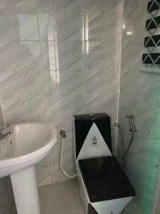 uma pequena casa de banho com lavatório e WC em Deoyem Place em Ikorodu