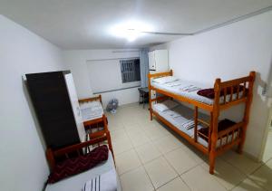 Mały pokój z 2 łóżkami piętrowymi i tablicą kredową w obiekcie Hostel Airport Rooms w São Paulo