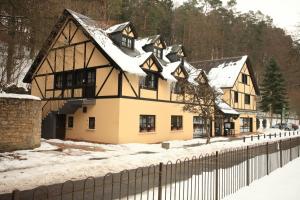 une maison dans la neige avec une clôture dans l'établissement Hotel Sieweburen, à Luxembourg