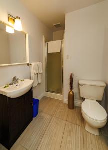 a bathroom with a toilet and a sink and a shower at Auberge La Marmite in La Malbaie