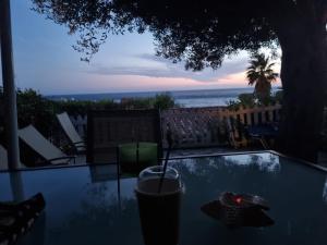 einen Glastisch mit einem Getränk darauf mit Meerblick in der Unterkunft Corfu Dream Holidays Villas 2-4 in Glyfada