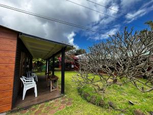 una terrazza in legno con tavolo e sedie. di Camping Hostal Tipanie Moana Aeropuerto Centro a Hanga Roa