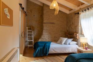 a bedroom with a bed and a brick wall at OLardoMar in Carnota