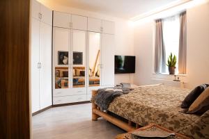 ein weißes Schlafzimmer mit einem Bett und einem Fernseher in der Unterkunft MD-7 Lutherstrasse 15 - Luxus-Wasserbett-SmartTV-Terrasse-2Schlafzimmer in Magdeburg
