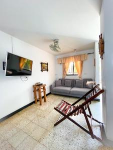 a living room with a couch and a tv at Cabaña La Aldea - Santorini Colombiano in Doradal