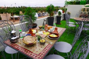 einen Tisch mit Speisen auf dem Balkon in der Unterkunft Winarouze house in Marrakesch