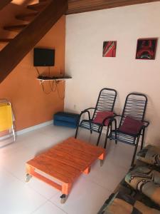 a living room with a wooden table and two chairs at CHALÉS DO GIBA in Maresias