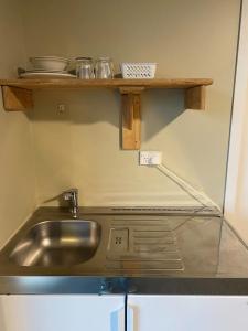 a kitchen with a sink and a shelf at Hokitika Holiday Park in Hokitika