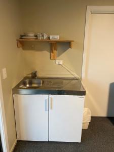 a small kitchen with a sink and a counter at Hokitika Holiday Park in Hokitika