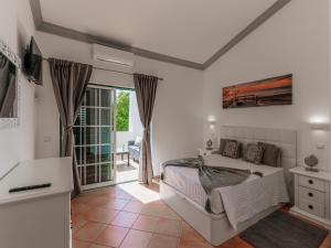 een witte slaapkamer met een bed en een balkon bij Luxury Townhouse Vila Rafaella2 n/ São Rafael Beach Albufeira in Albufeira