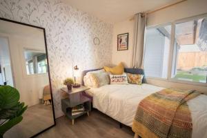 King Garden Suite/20 mins to Dwntwn Vancouvr/PetOk في نورث فانكوفر: غرفة نوم بسرير ومرآة ونافذة