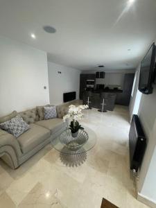 a living room with a couch and a glass table at Castle St Mews of Southport - 2 bed townhouse in Southport
