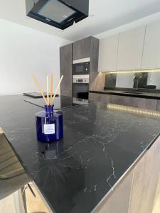 a kitchen with a black marble counter top with wooden sticks at Castle St Mews of Southport - 2 bed townhouse in Southport