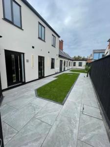 a courtyard of a white building with a grass yard at Castle St Mews of Southport - 2 bed townhouse in Southport