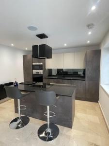 a kitchen with a counter and two bar stools at Castle St Mews of Southport - 2 bed townhouse in Southport