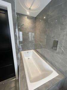 a bathroom with a white tub and a shower at Castle St Mews of Southport - 2 bed townhouse in Southport